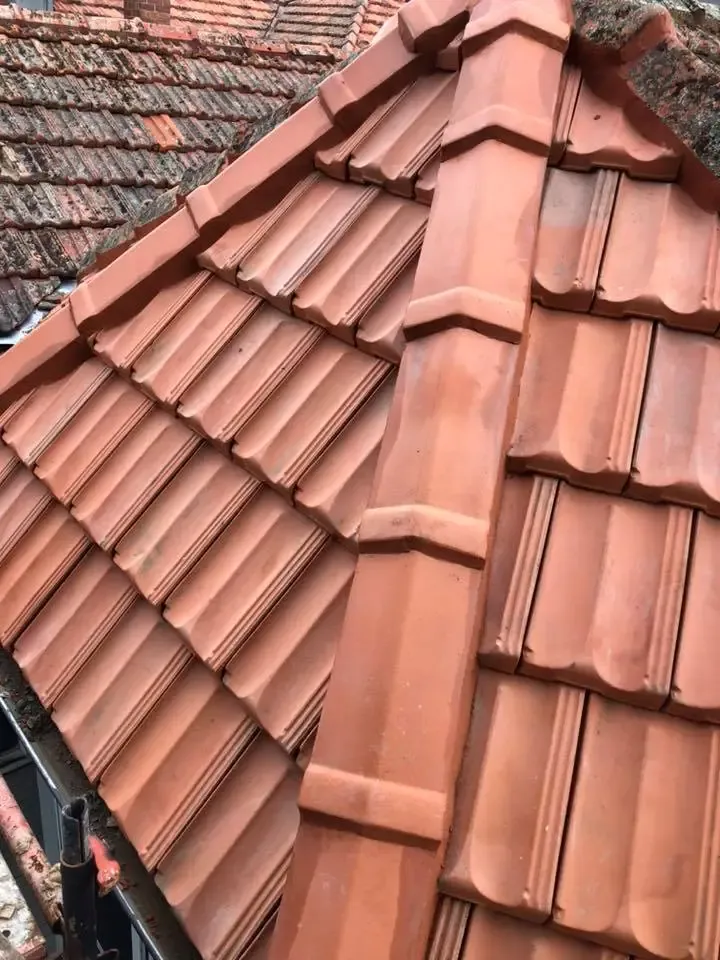 After: roof section re-tiled with new terracotta tiles and ridge capping