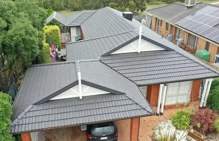After: the same tiled roof restored with a charcoal membrane coating