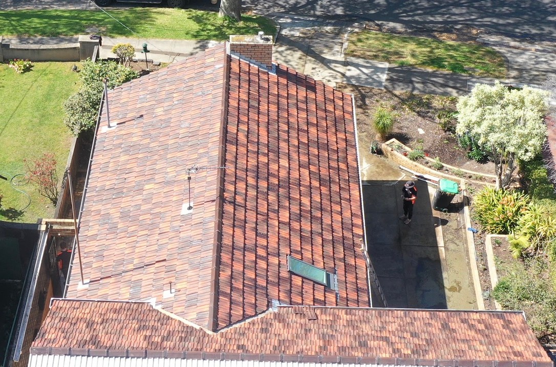 After: the same terracotta roof cleaned and restored, with the tiles back to their natural colour