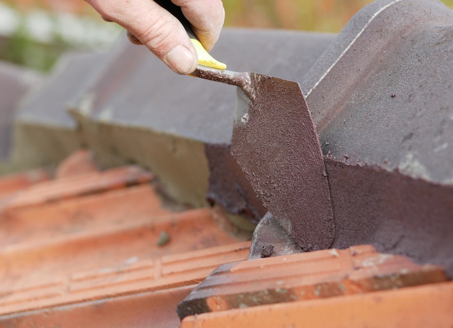 Close-up of a trowel finishing flexible pointing on ridge capping