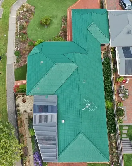 Before: a terracotta tiled roof covered in lichen and moss, seen from above by drone