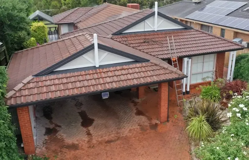 Before: faded, patchy red tiled roof on a brick home
