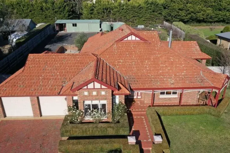 Before: weathered terracotta tiled roof covered in lichen