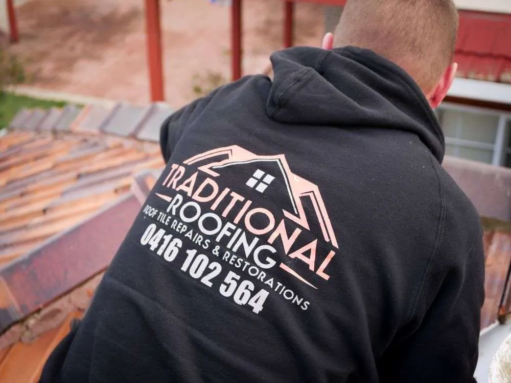 Traditional Roofing team member at work on a terracotta tiled roof