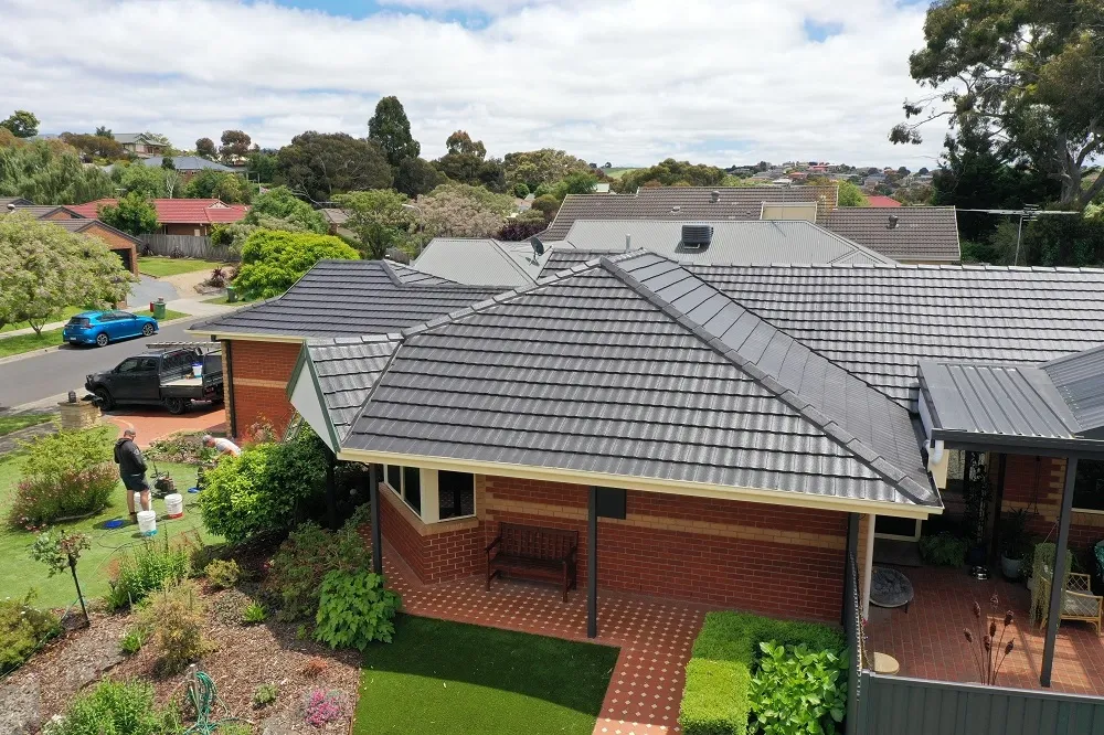 Aerial view of a charcoal concrete tiled roof on a brick home