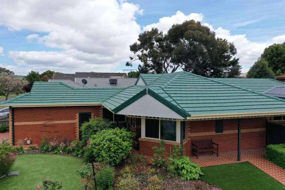Restored green tiled roof on a brick home in Melbourne
